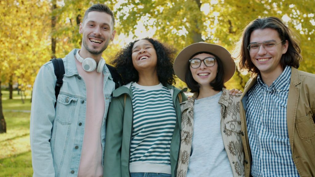 Gruppo di studenti universitari sorridenti in un campus, perfetti candidati per l'esame C1 Advanced.